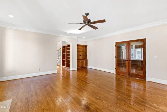 an empty room with wooden floor and window
