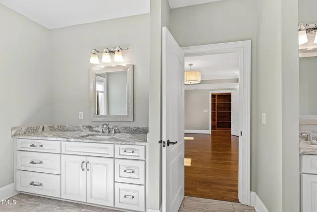 a bathroom with a granite countertop sink and a mirror