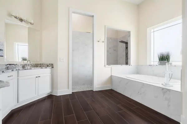 a spacious bathroom with double vanity and a bathtub