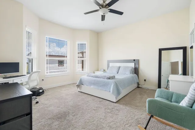 a bedroom with a bed flat screen tv and a large window