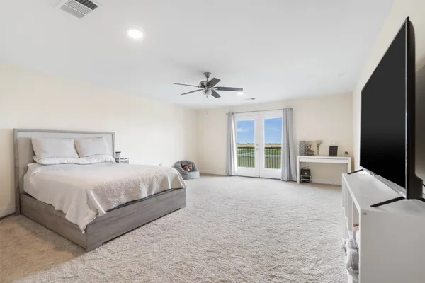 a spacious bedroom with a bed and a large window