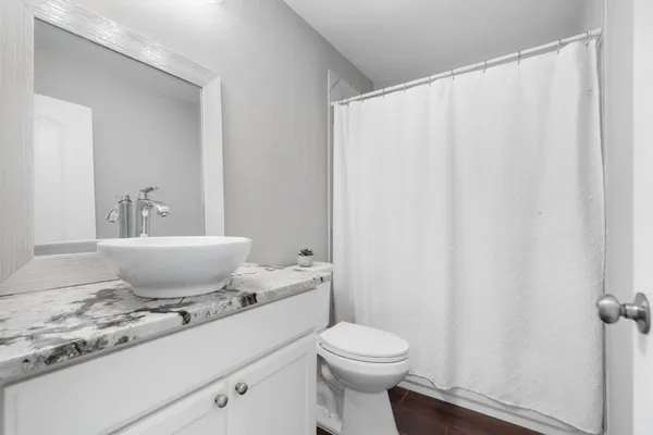 a bath room with a toilet a sink and a curtain