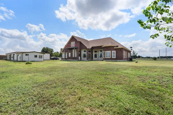 a large house with a big yard and large trees