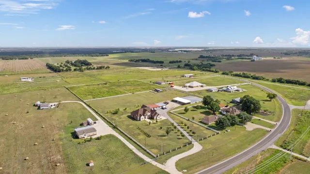 an aerial view of a house with a yard basket ball court and outdoor seating