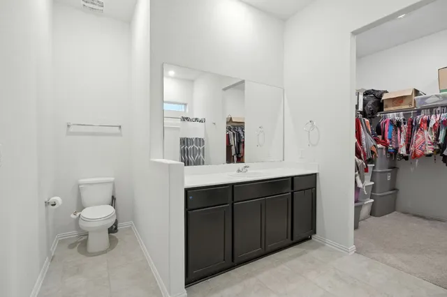 a bathroom with a sink a toilet and a large mirror