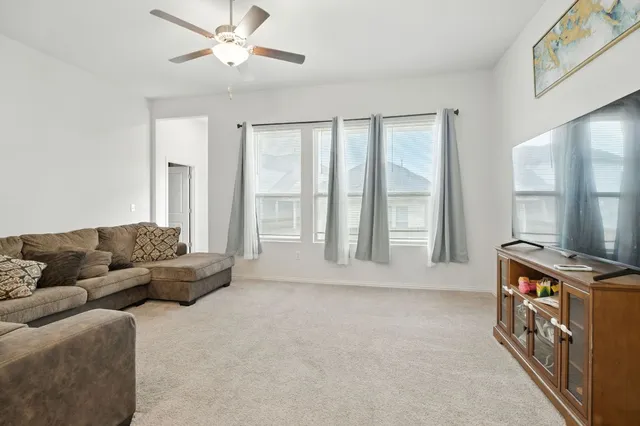 a living room with furniture and a ceiling fan