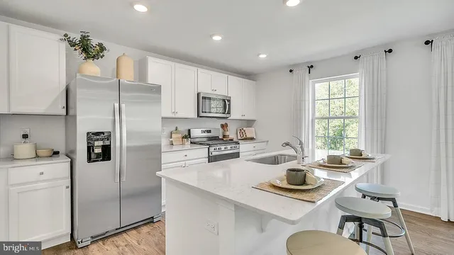 a kitchen with kitchen island a sink stove and refrigerator