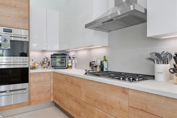 a kitchen with stainless steel appliances granite countertop a sink a stove and a wooden floors