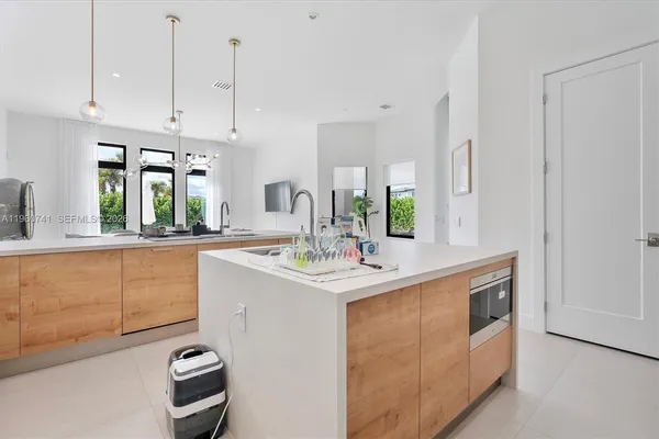 a kitchen with stainless steel appliances granite countertop a sink a stove and a wooden floors