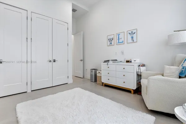 a spacious bedroom with a bed and a flat screen tv