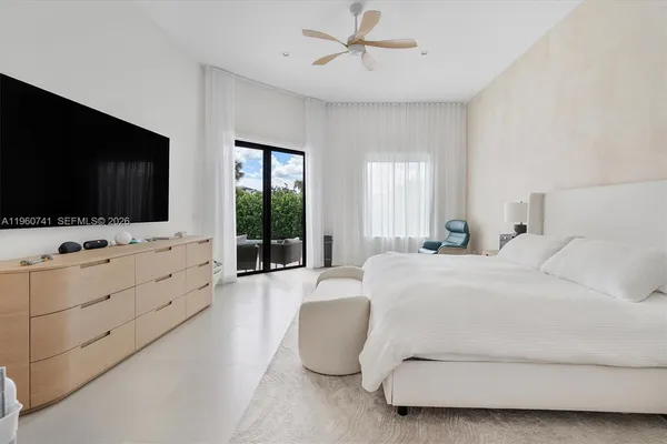 a bedroom with furniture window and flat screen tv