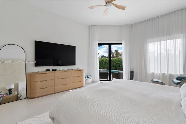 a bed room with flat screen tv and a window