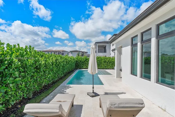 a view of a house with swimming pool and sitting area