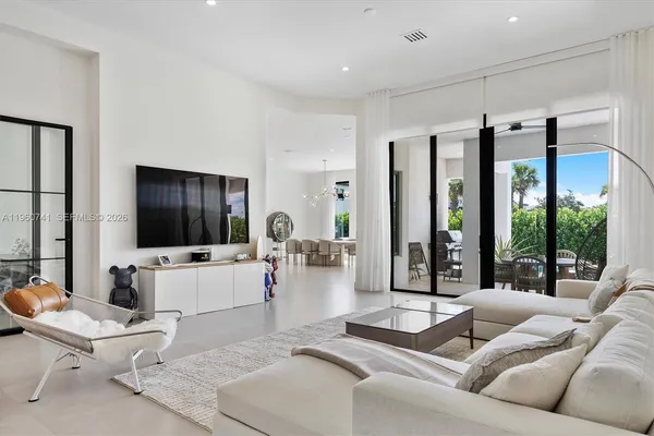 a living room with furniture flat screen tv and a large window