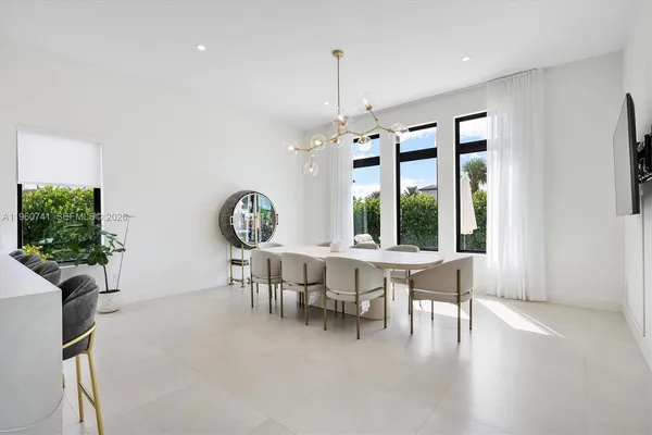 a dining room with furniture and a large window