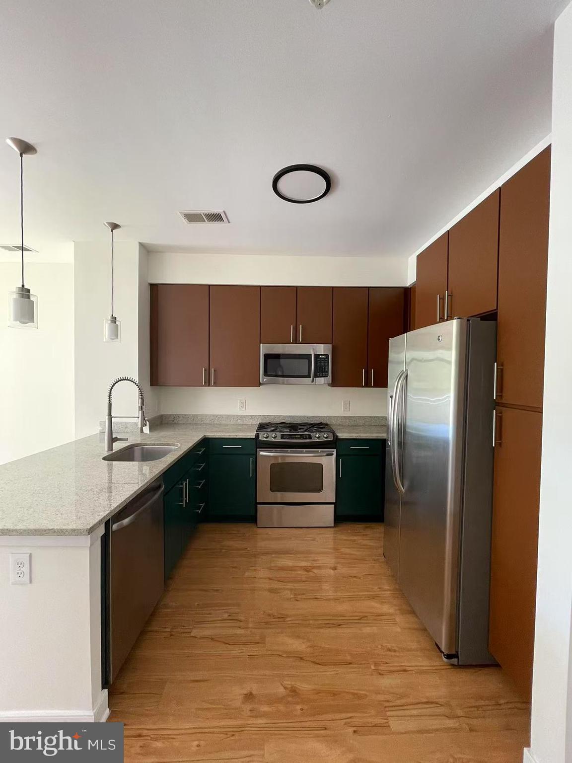 8005 13th Street, Unit 310 Silver Spring, MD 20910 - Photo 5 of 11 a kitchen with stainless steel appliances granite countertop a stove a refrigerator and a sink