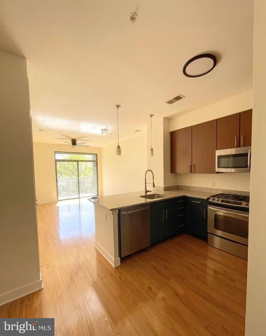8005 13th Street, Unit 310 Silver Spring, MD 20910 - Photo 6 of 11 a large kitchen with kitchen island granite countertop a sink window and stainless steel appliances