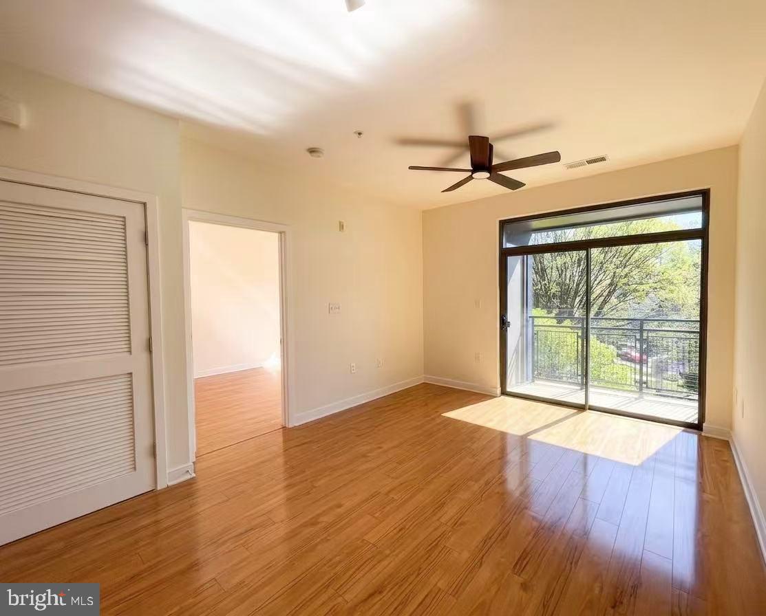 8005 13th Street, Unit 310 Silver Spring, MD 20910 - Photo 7 of 11 a view of an empty room with wooden floor and a window