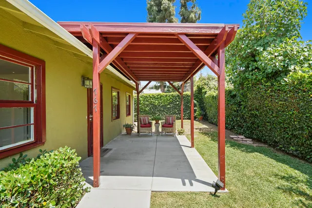 a backyard of a house with a garden and outdoor seating