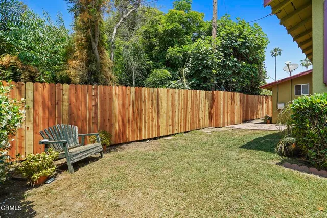 a view of a backyard with potted plants and wooden fence