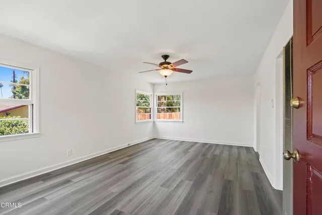 a view of a room with wooden floor and a ceiling fan