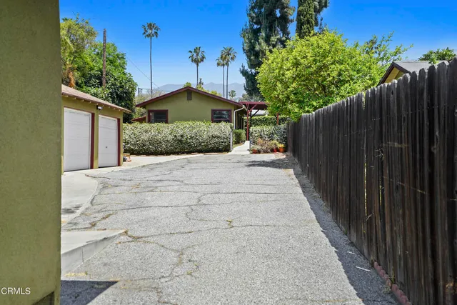 a view of a house with a small yard and wooden fence