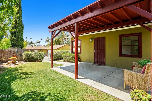a patio with a table and chairs and potted plants