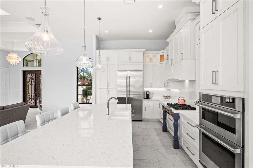 388 Pine Avenue Naples, FL 34108 - Photo 17 of 34 a kitchen with stainless steel appliances kitchen island granite countertop a stove a sink and a refrigerator