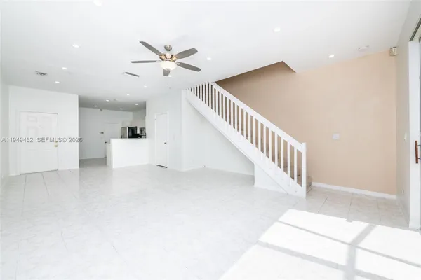 a view of kitchen with stainless steel appliances kitchen island sink refrigerator and microwave