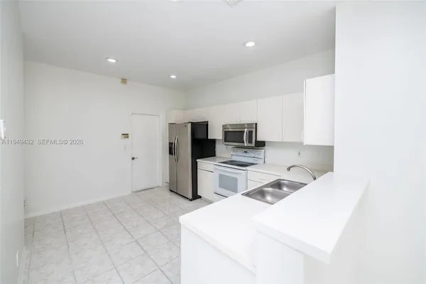 a large kitchen with a sink and cabinets