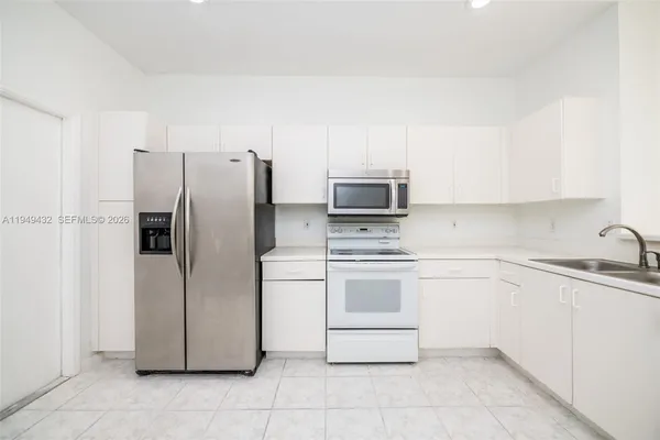 a kitchen with stainless steel appliances a refrigerator sink and microwave
