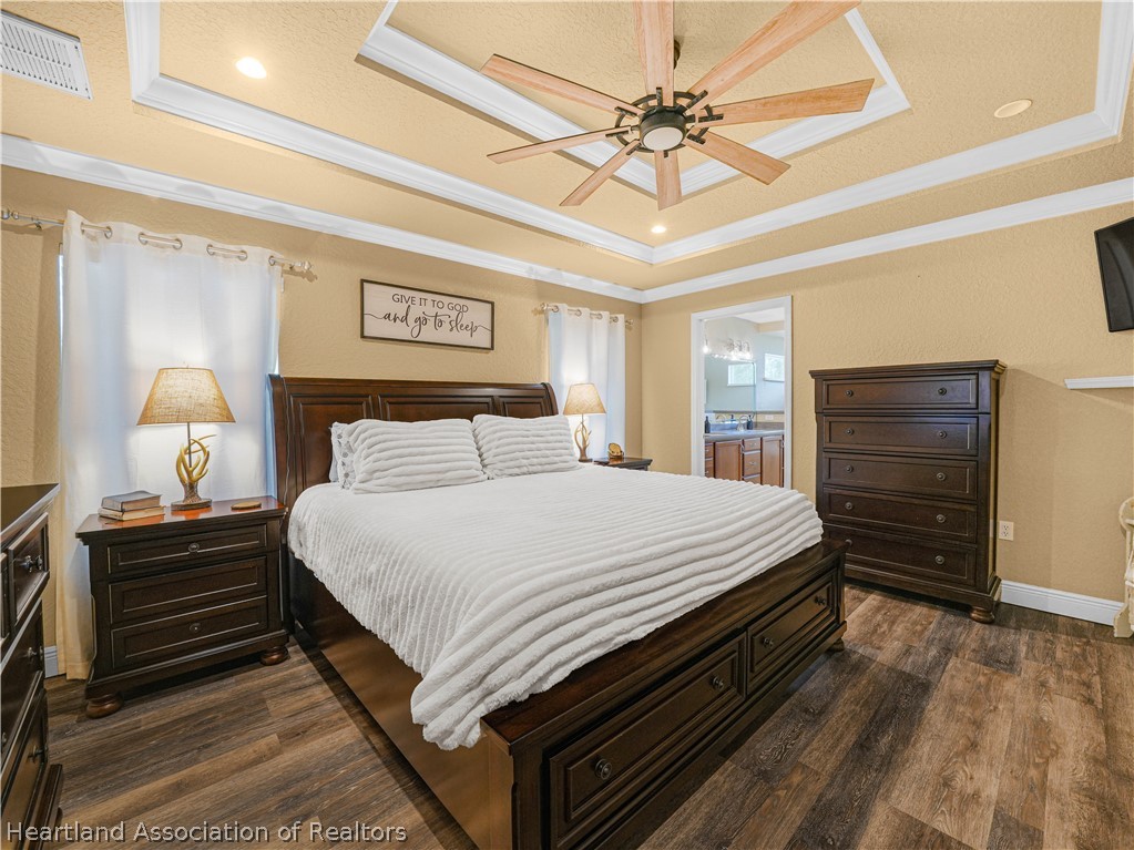 5430 Lakewood Road Sebring, FL 33875 - Photo 13 of 40 a bedroom with a bed and a chandelier