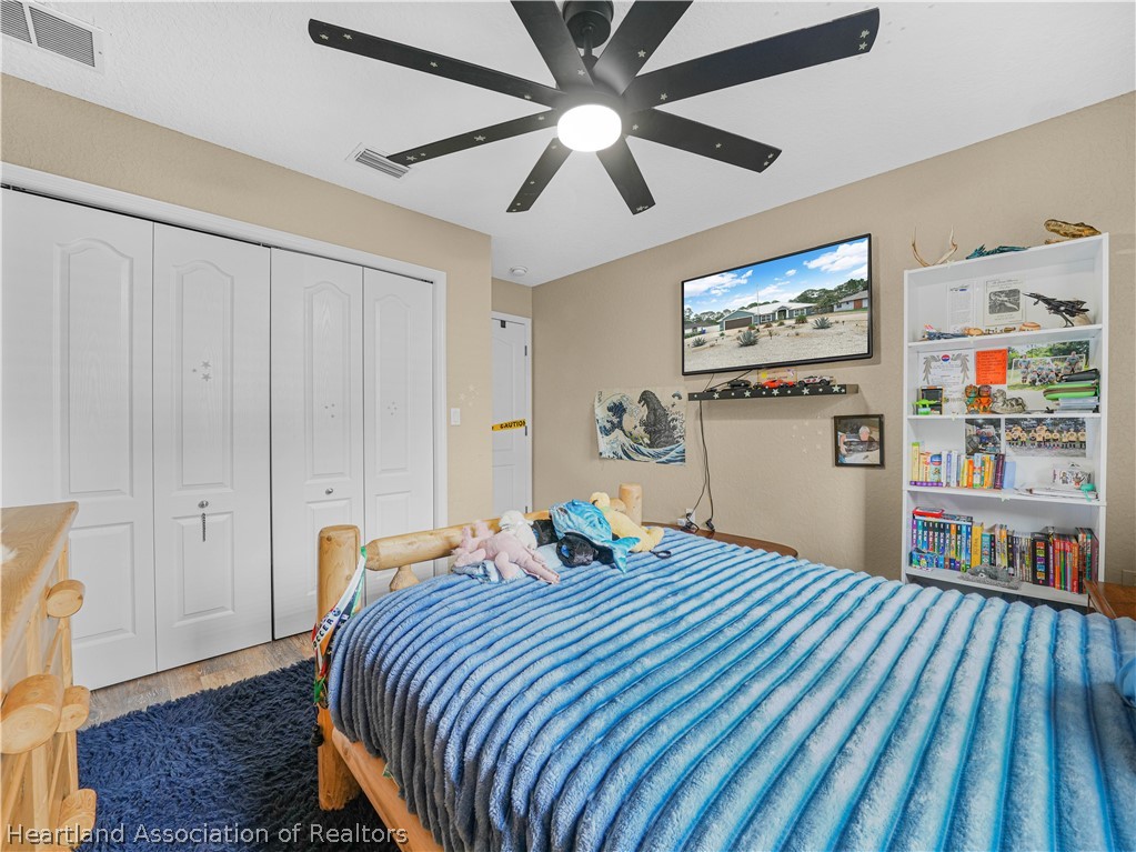 5430 Lakewood Road Sebring, FL 33875 - Photo 21 of 40 a bedroom with bed and wooden floor