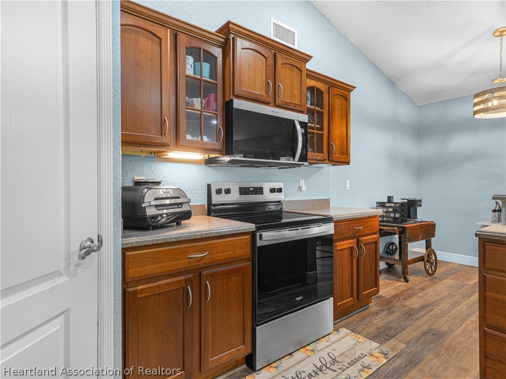 5430 Lakewood Road Sebring, FL 33875 - Photo 10 of 40 a kitchen with stainless steel appliances granite countertop a stove top oven a sink dishwasher and cabinets with wooden floor