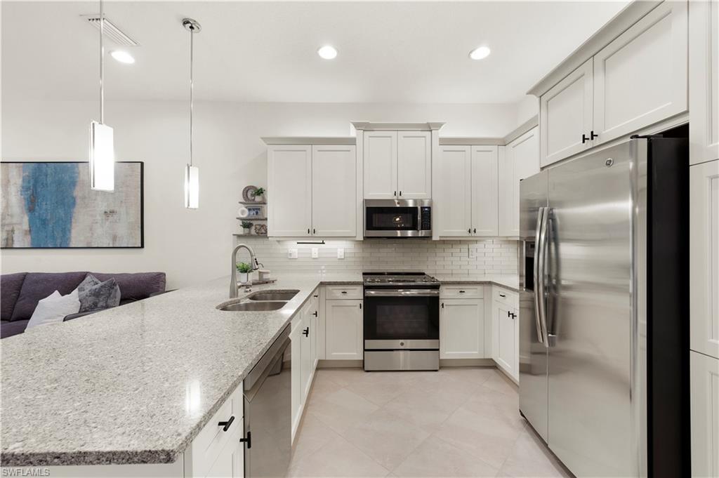 11989 Five Waters Circle Fort Myers, FL 33913 - Photo 6 of 32 a kitchen with stainless steel appliances a refrigerator sink and stove