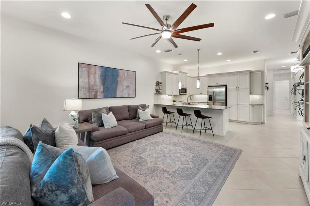 11989 Five Waters Circle Fort Myers, FL 33913 - Photo 7 of 32 a living room with furniture and a chandelier