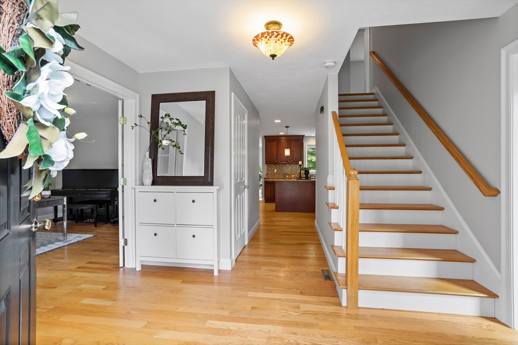 3 Gilson Road Littleton, MA 01460 - Photo 13 of 36 a view of a hallway to a livingroom with wooden floor and furniture