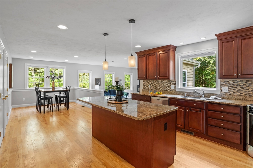 3 Gilson Road Littleton, MA 01460 - Photo 18 of 36 a kitchen with kitchen island granite countertop a sink a counter top space and living room view