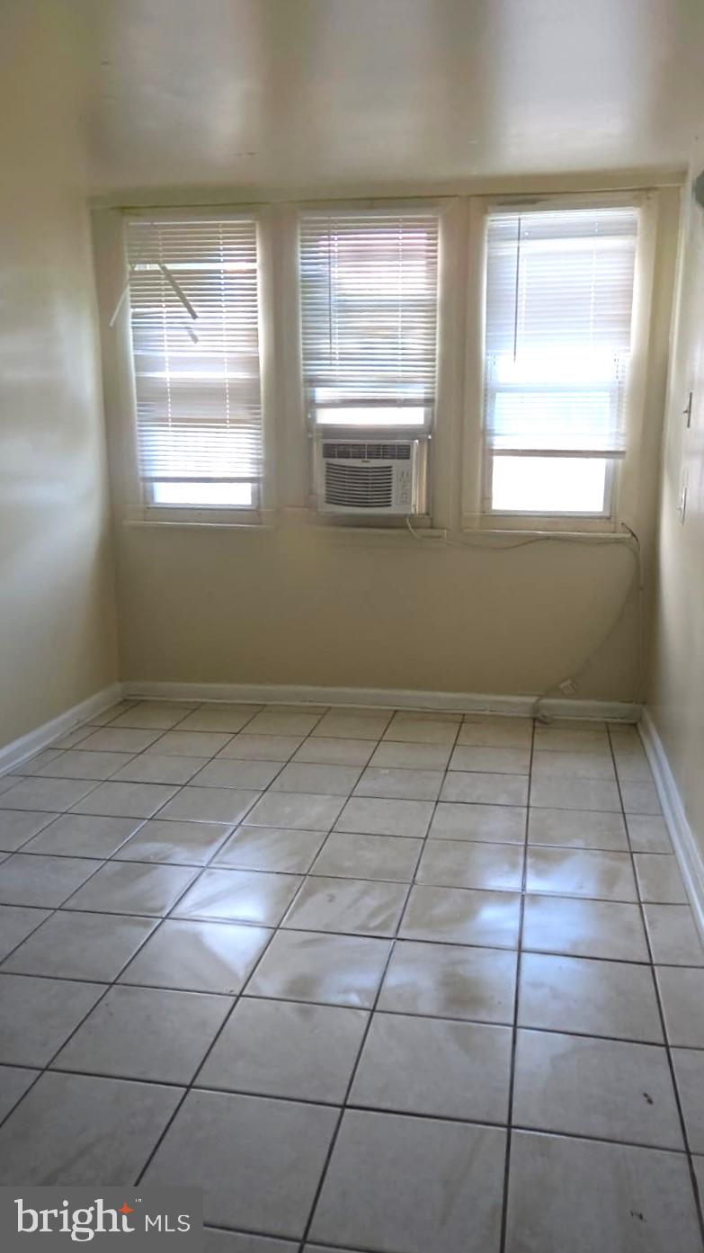5202 F Street Philadelphia, PA 19124 - Photo 8 of 14 a room with a black white checkered floor and a window