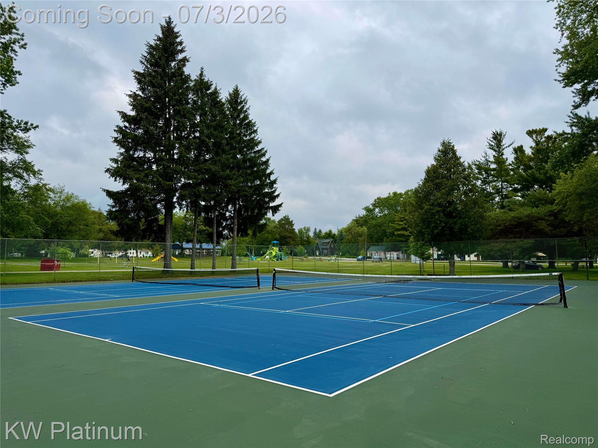 7955 Lakeshore Road Fort Gratiot, MI 48059 - Photo 25 of 30 Two blue hard-surface tennis courts with white line markings and nets
