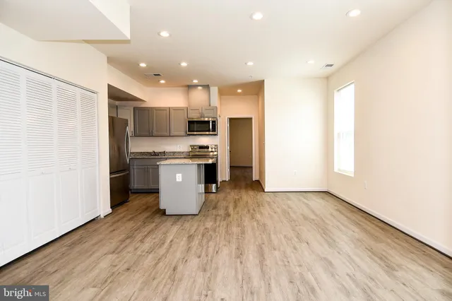 a kitchen with stainless steel appliances a refrigerator and a stove top oven