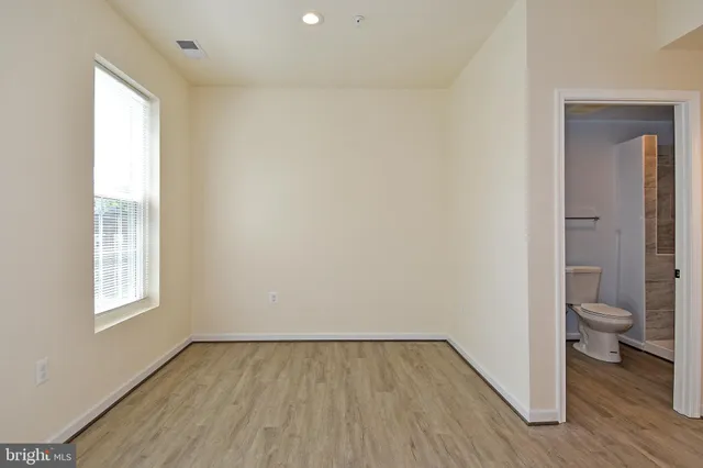 an empty room and a bathroom with toilet