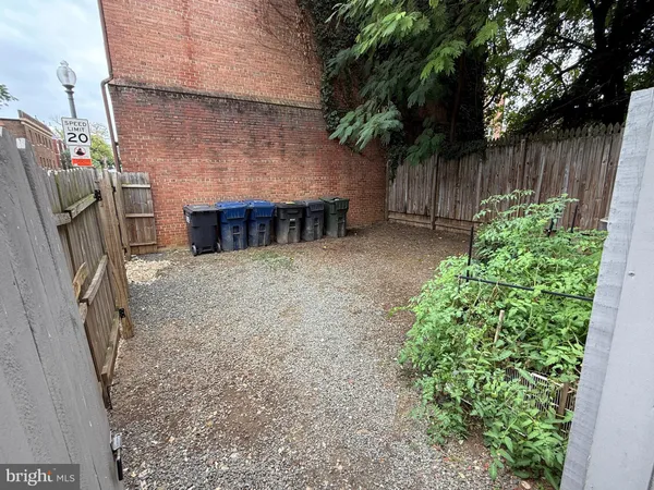 a view of backyard with potted plants and wooden fence
