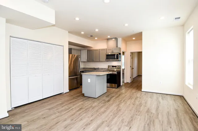 a kitchen with stainless steel appliances a refrigerator and a stove top oven