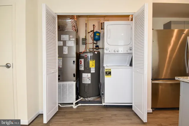 a view of a refrigerator in kitchen and an empty room