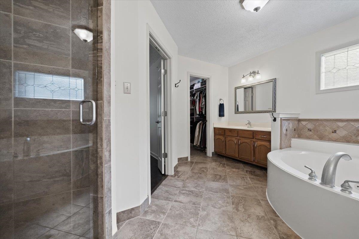 276 Morton Road Collierville, TN 38017 - Photo 15 of 33 a bathroom with a tub a sink a mirror and a shower