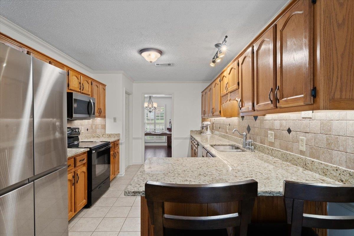 276 Morton Road Collierville, TN 38017 - Photo 5 of 33 a kitchen with stainless steel appliances granite countertop table chairs sink refrigerator and stove