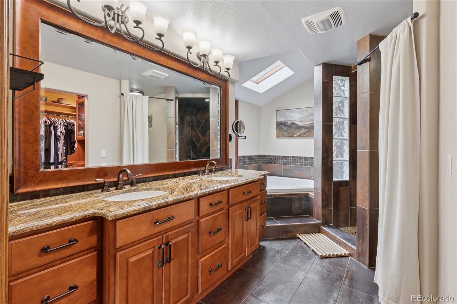 7501 Stroh Road Parker, CO 80134 - Photo 21 of 49 a bathroom with a granite countertop double vanity sink and a mirror