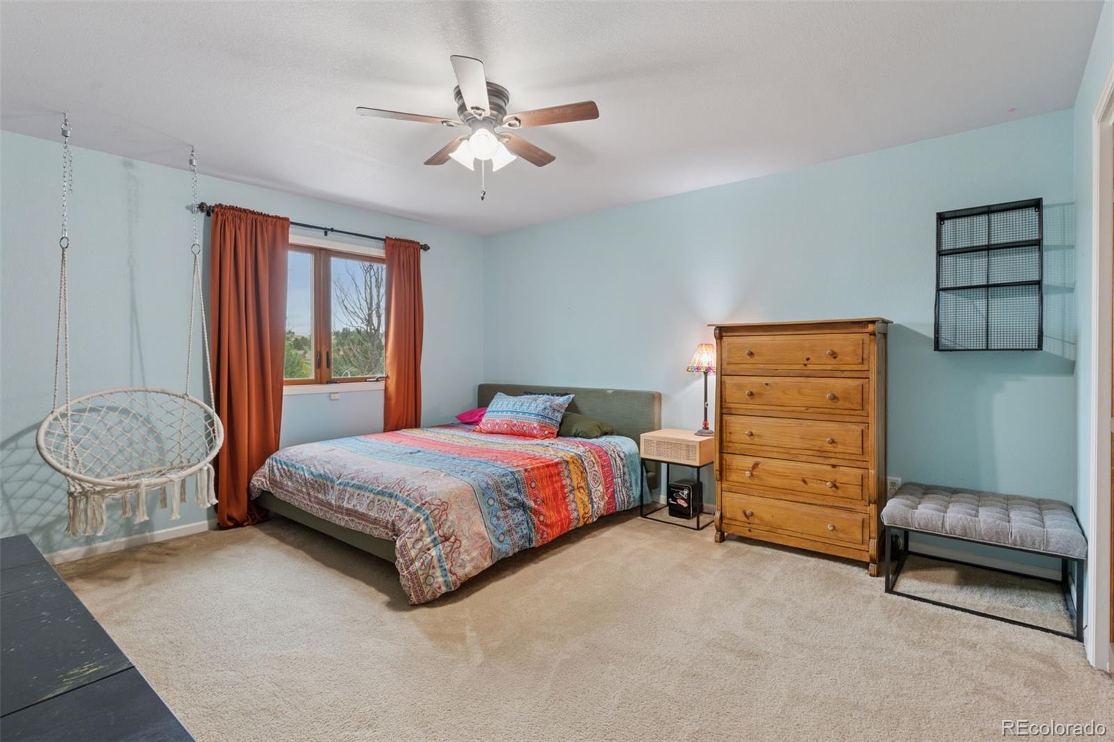 7501 Stroh Road Parker, CO 80134 - Photo 30 of 49 a bedroom with a bed and a chandelier