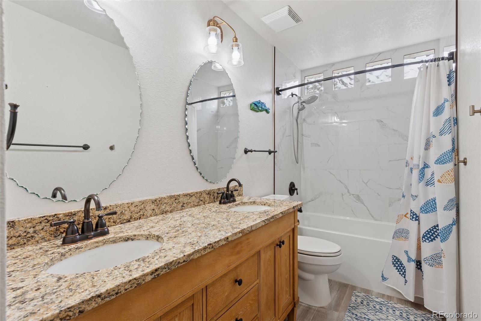 7501 Stroh Road Parker, CO 80134 - Photo 31 of 49 a bathroom with a granite countertop sink mirror vanity and toilet